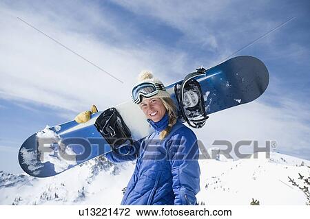 Woman holding snowboard View Large Photo Image Stock Image - Woman holding snowboard. Fotosearch