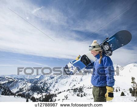 Stock Photo - Woman holding snowboard, Wasatch Mountains, Utah, United States. Fotosearch