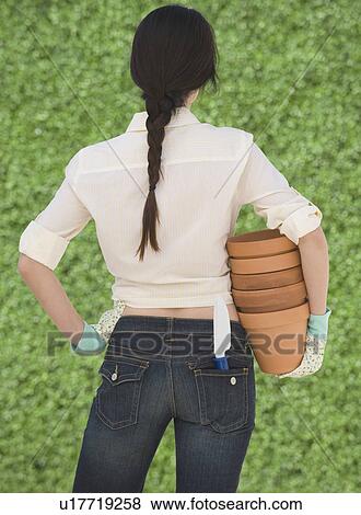 Stock Photo - Woman holding terra cotta pots. Fotosearch