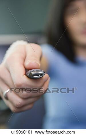 Stock Image - Woman holding USB drive. Fotosearch
