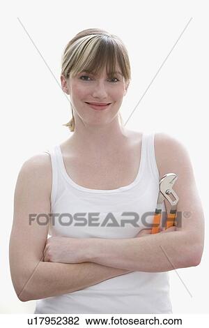 Stock Image - Woman holding wrench. Fotosearch