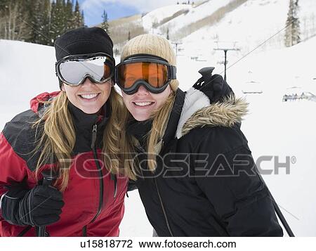 Stock Image - Woman in ski gear hugging. Fotosearch