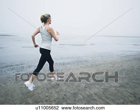 Woman jogging on beach View Large Photo Image Stock Image - Woman jogging on beach. Fotosearch