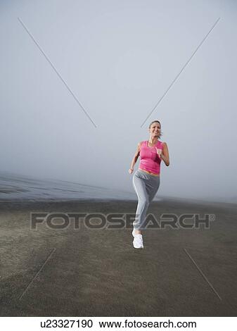Woman jogging on foggy beach View Large Photo Image Stock Image - Woman jogging on foggy beach. Fotosearch