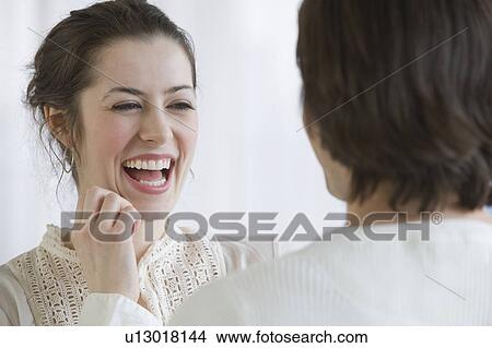 Woman laughing next to boyfriend View Large Photo Image Picture - Woman laughing next to boyfriend. Fotosearch