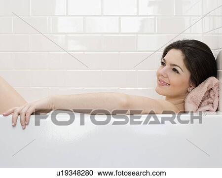 Stock Image - Woman laying in bathtub. Fotosearch