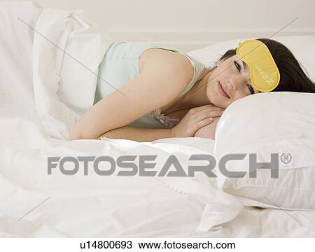 Woman laying in bed with eye mask View Large Photo Image Stock Image - Woman laying in bed with eye mask. Fotosearch