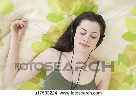Picture - Woman listening to headphones. Fotosearch