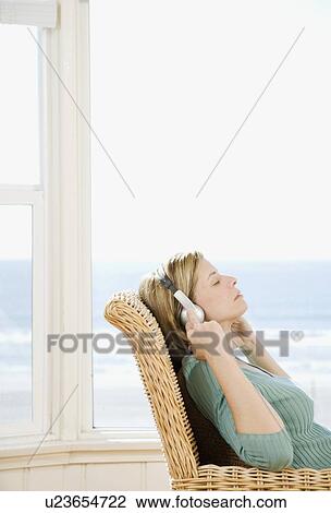 Woman listening to headphones View Large Photo Image Stock Image - Woman listening to headphones. Fotosearch