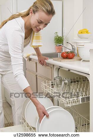 Woman loading plates in dishwasher View Large Photo Image Stock Photography - Woman loading plates in dishwasher. Fotosearch