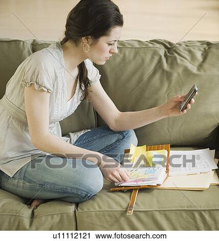 Stock Image - Woman looking at electronic organizer. Fotosearch