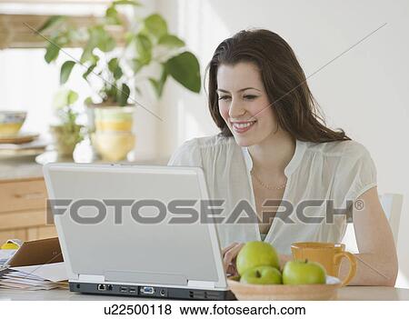 Stock Photo - Woman looking at laptop. Fotosearch