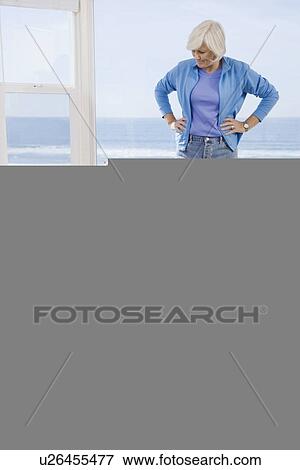 Stock Photo - Woman looking at man sleeping next to vacuum. Fotosearch