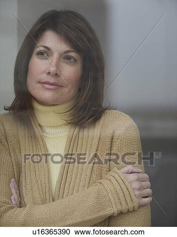 Stock Image - Woman looking out window pensively. Fotosearch