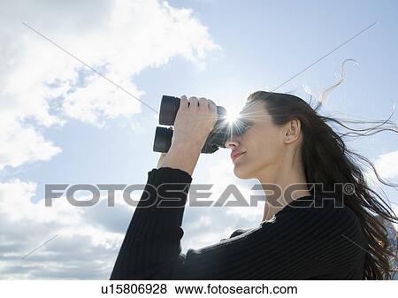 Stock Photo - Woman looking through binoculars. Fotosearch