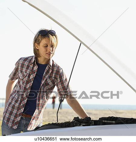Woman looking under car hood View Large Photo Image Stock Image - Woman looking under car hood. Fotosearch