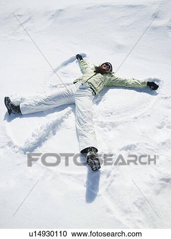 Stock Image - Woman making snow angel. Fotosearch