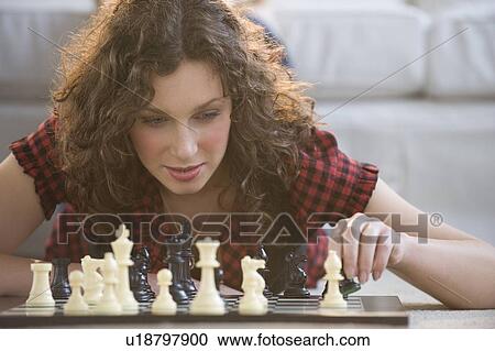 Stock Image - Woman moving chess piece. Fotosearch
