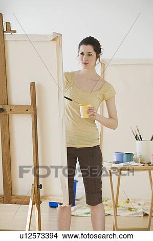 Woman painting on easel View Large Photo Image Picture - Woman painting on easel. Fotosearch