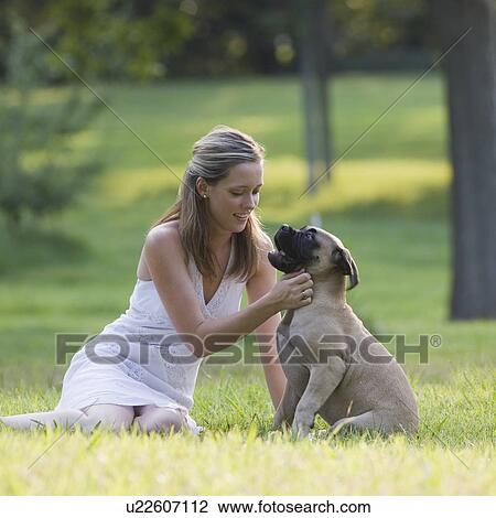 Woman petting dog in park View Large Photo Image Stock Image - Woman petting dog in park. Fotosearch