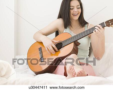 Stock Image - Woman playing guitar. Fotosearch