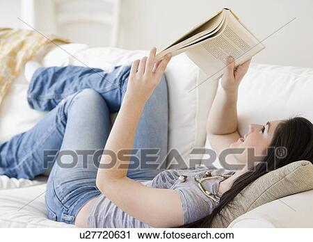Woman reading book on sofa View Large Photo Image Stock Image - Woman reading book on sofa. Fotosearch