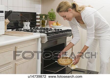 Woman removing pie from oven View Large Photo Image Stock Image - Woman removing pie from oven. Fotosearch