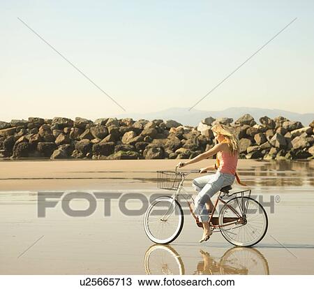 Woman riding bicycle on beach View Large Photo Image Stock Image - Woman riding bicycle on beach. Fotosearch