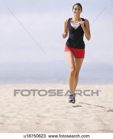 Stock Image - Woman running on beach. Fotosearch