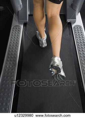 Stock Image - Woman running on treadmill. Fotosearch