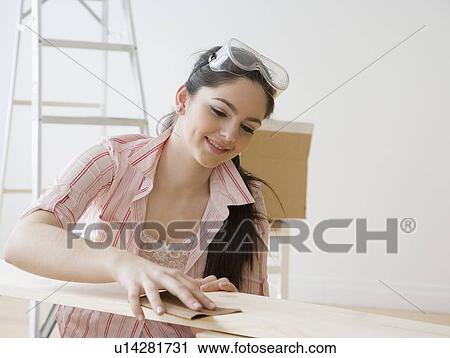 Woman sanding piece of wood View Large Photo Image Stock Image - Woman sanding piece of wood. Fotosearch