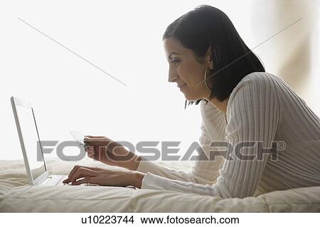 Picture - Woman shopping online. Fotosearch