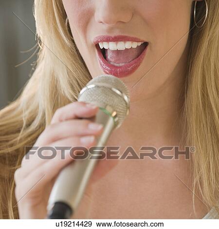Stock Photo - Woman singing into microphone. Fotosearch