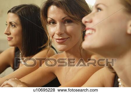 Stock Photo - Woman sitting between friends. Fotosearch
