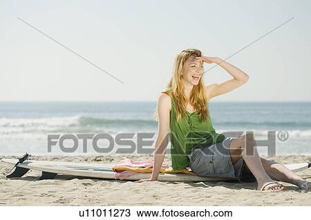 Woman sitting on surfboard View Large Photo Image Stock Image - Woman sitting on surfboard. Fotosearch