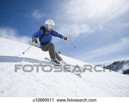 Stock Image - Woman skiing downhill. Fotosearch