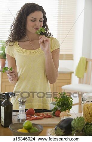 Woman smelling herbs and preparing meal View Large Photo Image Picture - Woman smelling herbs and preparing meal. Fotosearch