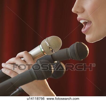 Stock Photograph - Woman speaking into microphone. Fotosearch