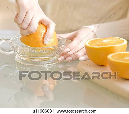 Stock Image - Woman squeezing oranges. Fotosearch