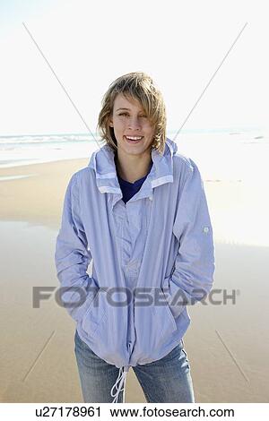 Stock Image - Woman standing on beach. Fotosearch