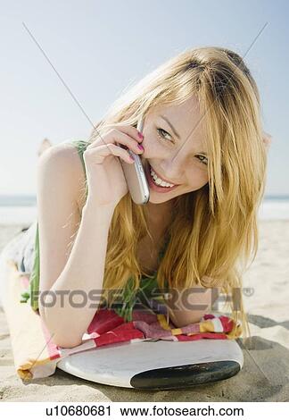 Stock Image - Woman talking on cell phone at beach. Fotosearch