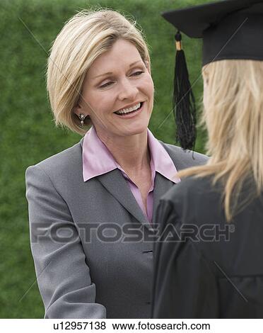 Stock Photo - Woman talking to graduate. Fotosearch