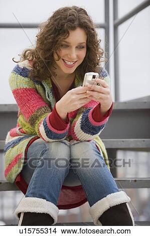 Woman text messaging on cell phone View Large Photo Image Picture - Woman text messaging on cell phone. Fotosearch