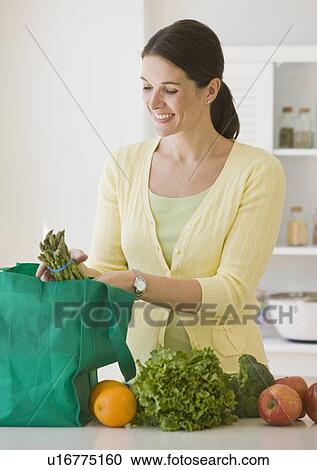 Woman unpacking groceries View Large Photo Image Stock Image - Woman unpacking groceries. Fotosearch