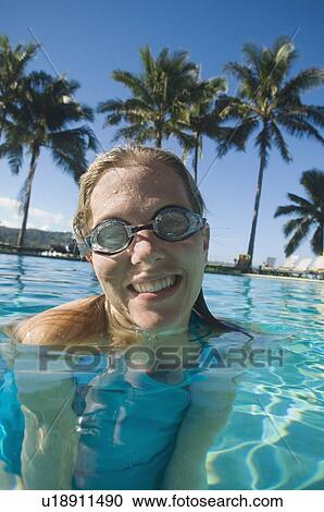 Stock Image - Woman wearing goggles in swimming pool. Fotosearch