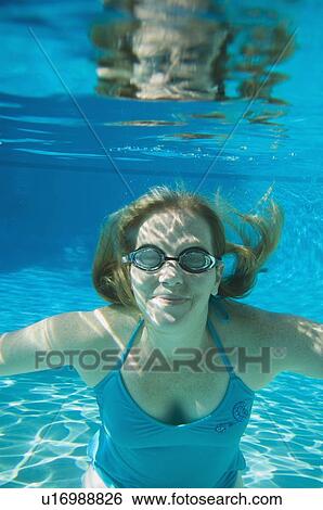 Stock Photograph - Woman wearing goggles underwater. Fotosearch