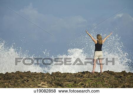 Woman with arms raised in front of ocean, Oahu, Hawaii, United States View Large Photo Image Stock Photo - Woman with arms raised in front of ocean, Oahu, Hawaii, United States. Fotosearch