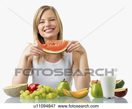 Woman with assorted fruit and glass of milk View Large Photo Image Stock Photo - Woman with assorted fruit and glass of milk. Fotosearch