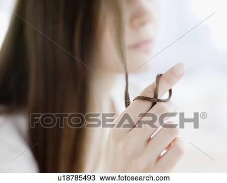 Woman with hair wrapped around finger View Large Photo Image Stock Image - Woman with hair wrapped around finger. Fotosearch