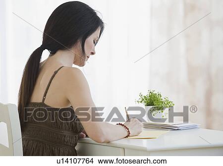 Woman writing at desk View Large Photo Image Picture - Woman writing at desk. Fotosearch